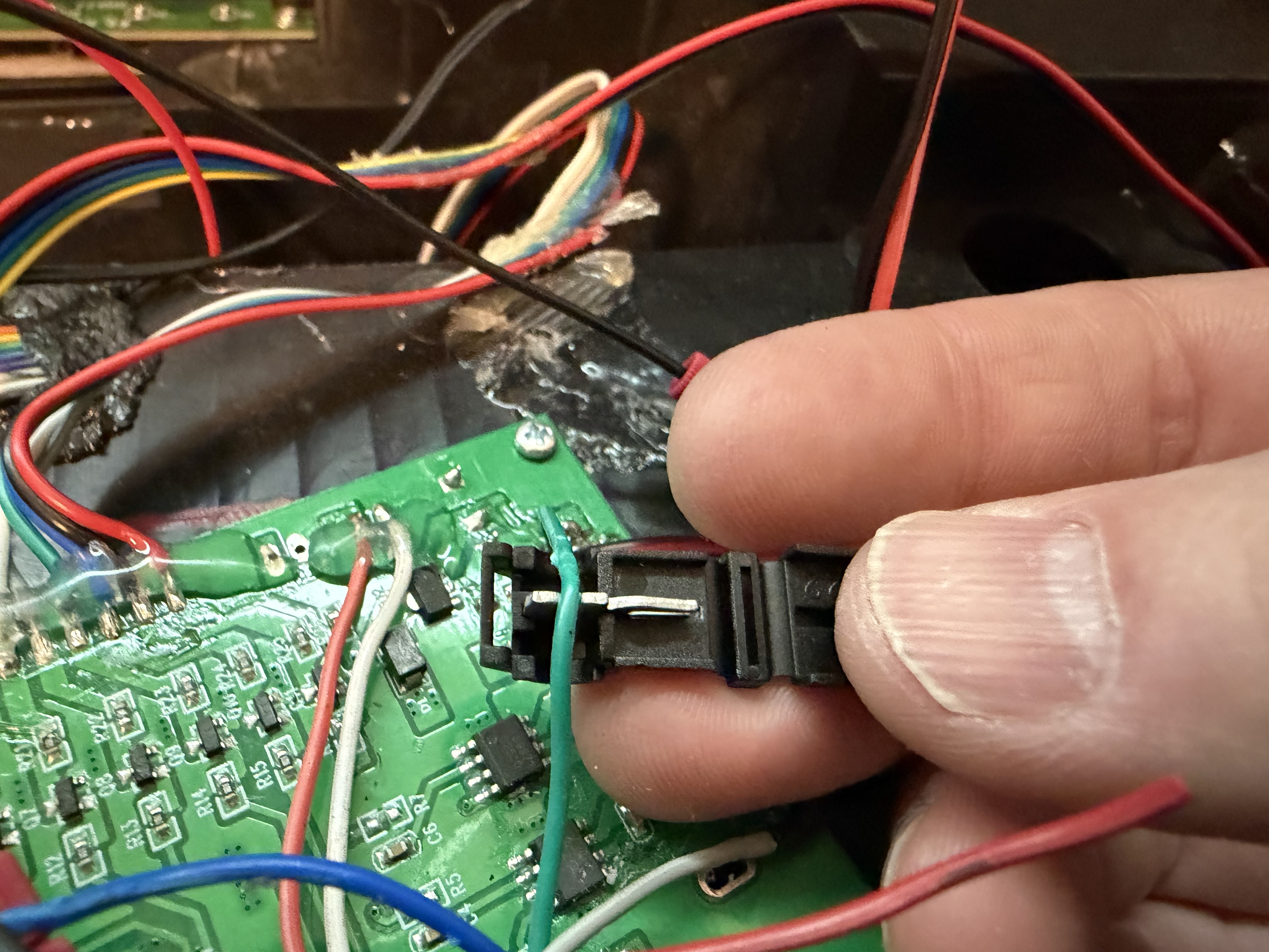 Red and black ProtonPal wires positioned in wire tap connectors on the factory power wires