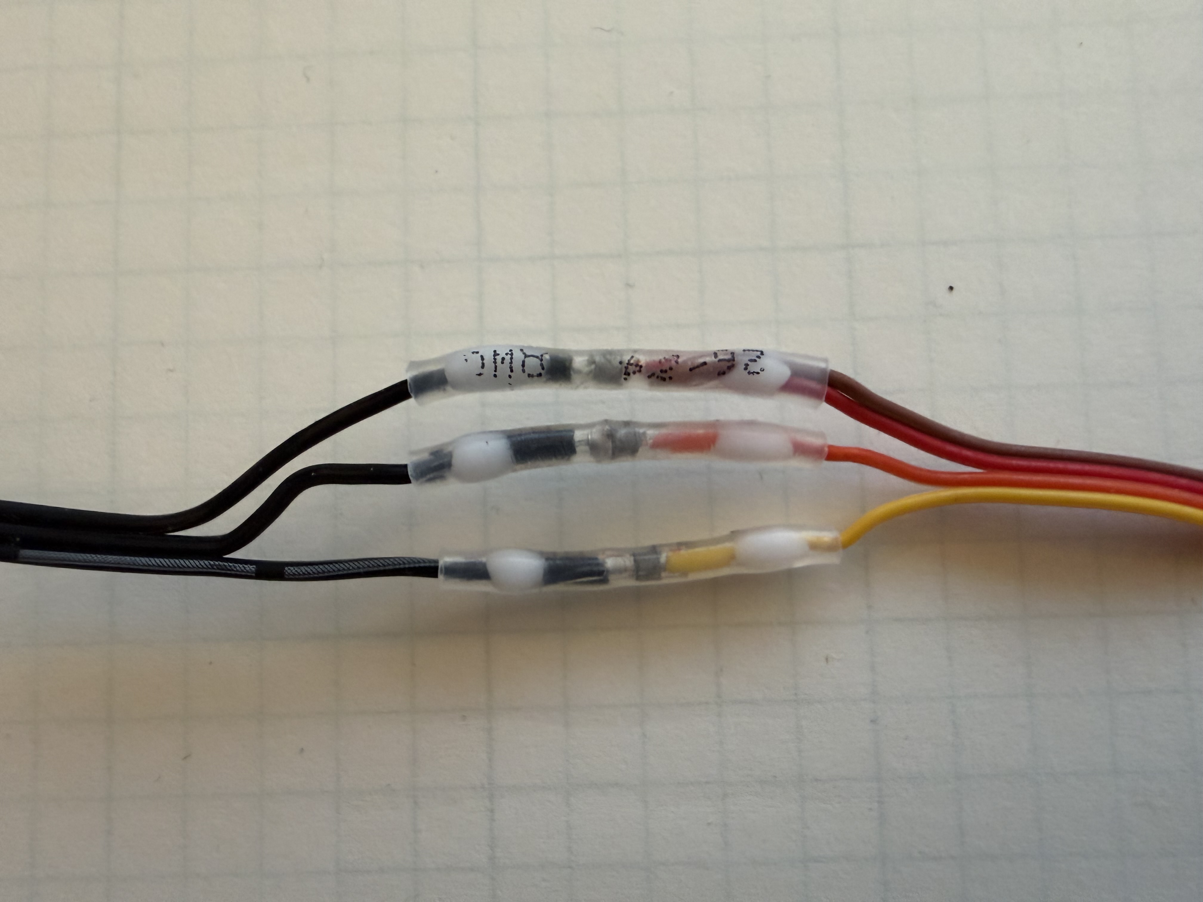 Close-up of three completed heat-shrink solder-seal wire connections